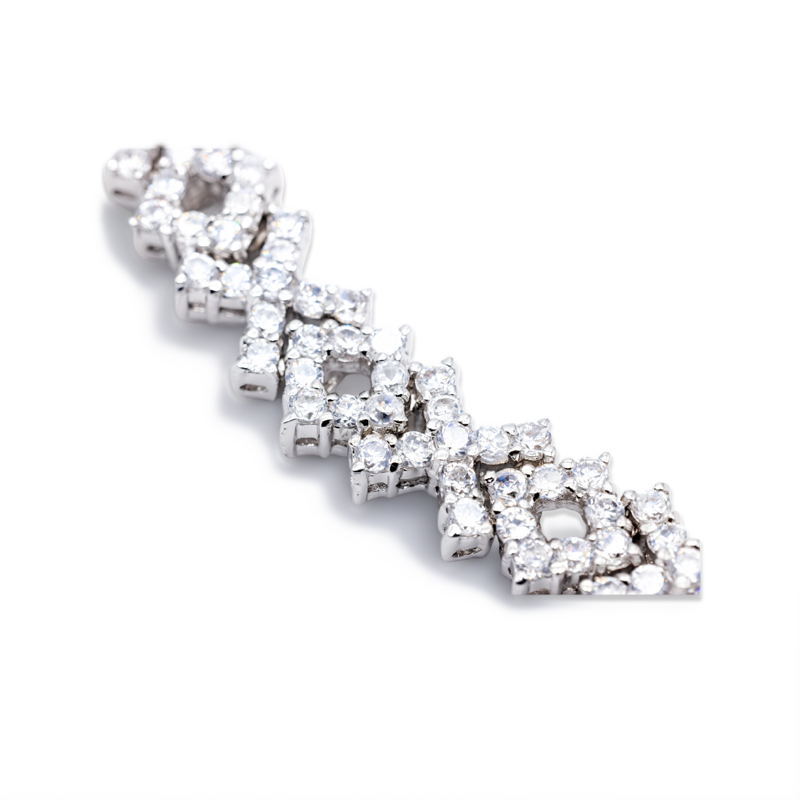Nahaufnahme des Cluster-Musters eines silberfarbenen Tennisarmbands mit klaren Zirkonia, gefüllte und offene Formen im Detail.